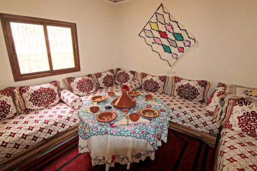 a living room with a couch and a table with food on it at Jnane Karma in Imlil