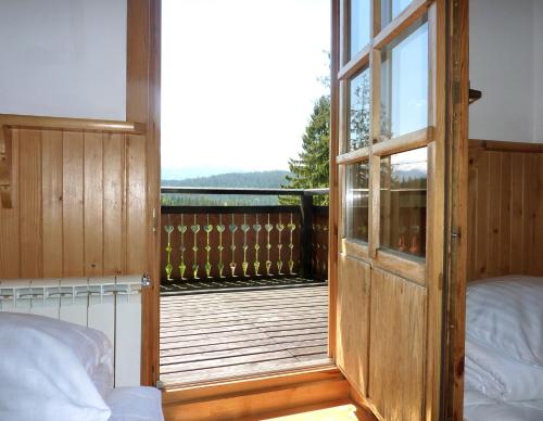 a room with a door and a balcony with a bed at Willa Litka in Bukowina Tatrzańska