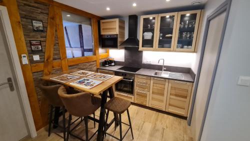 une petite cuisine avec une table et des chaises en bois dans l'établissement Appartement duplex climatisé avec terrasse 