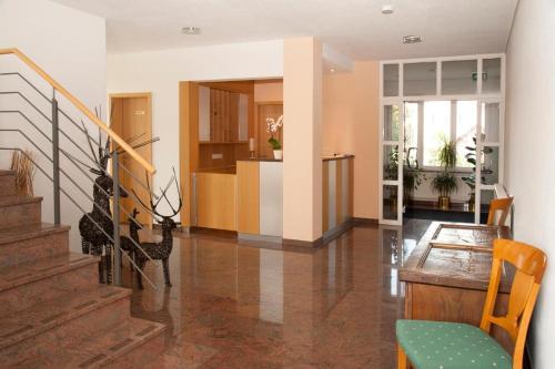 a living room with a staircase and a table at Hotel Villa Martino - zum Hirsch in Bad Säckingen