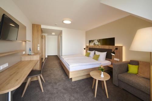 a hotel room with a bed and a couch at Kreuz-Post Hotel-Restaurant-SPA in Vogtsburg