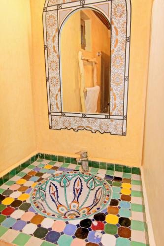 a bathroom with a mosaic sink in front of a mirror at Jnane Karma in Imlil