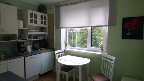 una pequeña cocina con mesa y ventana en Pärna külaliskorter en Vaemla