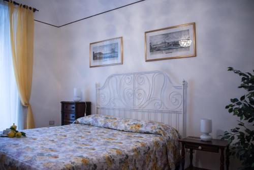 1 dormitorio con 1 cama y 2 cuadros en la pared en Il Giglio Rosso, en Nápoles