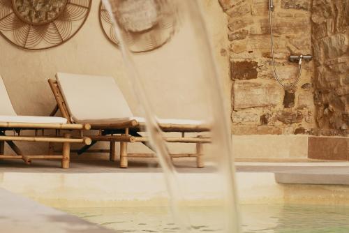 a chair sitting next to a pool of water at LA FUGUE chambres d hôtes de charme dans une demeure historique Proche UZES NIMES ALES in Brignon