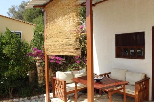 a patio with a wooden table and chairs at Rocka View in Meganisi