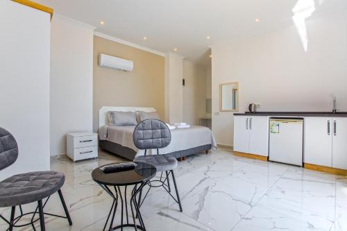 a bedroom with a bed and two chairs and a kitchen at Nur Suites & Hotels in Kalkan