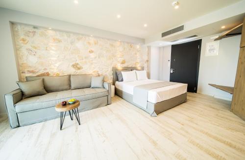 a bedroom with a bed and a couch at Kali Thea Suites in Neos Marmaras
