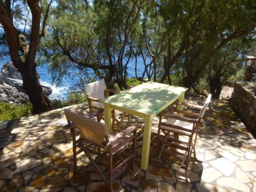 a table and chairs with a table and some water at Katafigio Village in Kotrónion