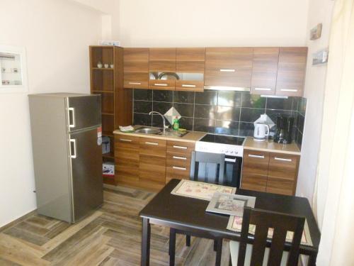 a small kitchen with a table and a refrigerator at Katafigio Village in Kotrónion