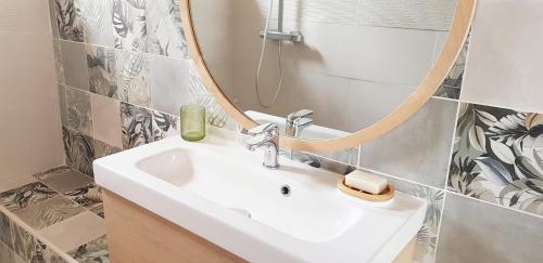 a bathroom with a sink and a mirror at Gîte Lucian Mont-saint-michel in Moidrey