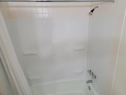 斯帕坦堡的住宿－USA Economy Lodge，浴室设有白色瓷砖墙和淋浴。