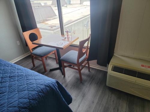 a small table and chairs in a room with a window at USA Economy Lodge in Spartanburg