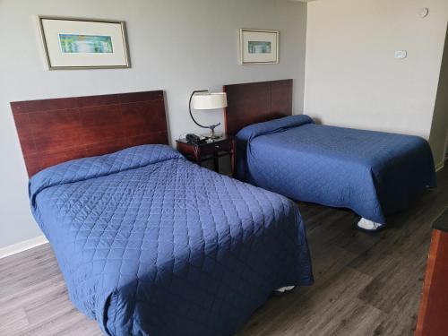two beds in a hotel room with blue covers at USA Economy Lodge in Spartanburg