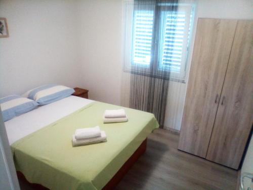 um quarto com uma cama com duas toalhas em Apartman Ivano em Kaštela