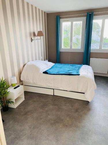 une chambre avec un lit et deux fenêtres dans l'établissement Appartement La Rotonde vue sur mer, à Saint-Valery-en-Caux