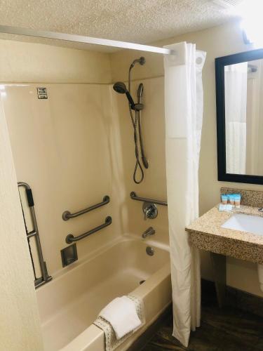a bathroom with a bath tub and a sink at Quail Inn and Suites - Myrtle Beach in Myrtle Beach