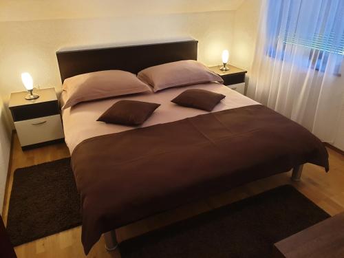 a bedroom with a large bed with two pillows at Guest Accommodation Marko Kesić in Grabovac