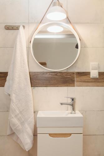 a bathroom with a white sink and a mirror at Pod Jasną 28 in Częstochowa