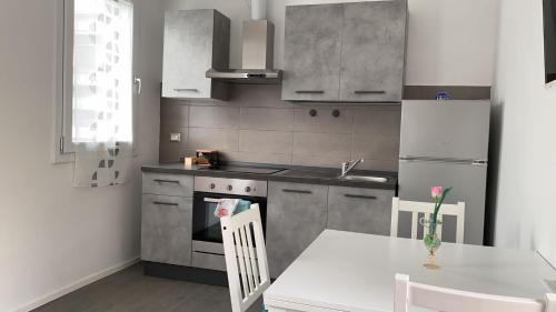 kuchnia ze stołem, białym stołem i krzesłami w obiekcie Momy House w mieście San Donà di Piave