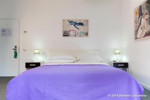 a bedroom with a purple bed with two night stands at Villa Pirandello in Rome