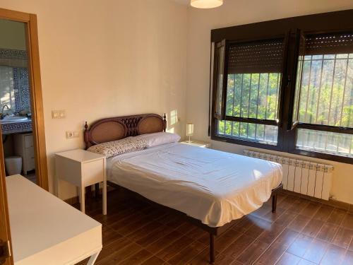 a bedroom with a bed and two windows at Chalet Dani con gallinero y parcela de 1000m a 5min de Puy Du Fou in Argés