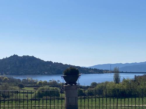 a planter on a fence with a view of a lake at Los Cedros, gran chalet con piscina y apartamento en Navacerrada in Navacerrada