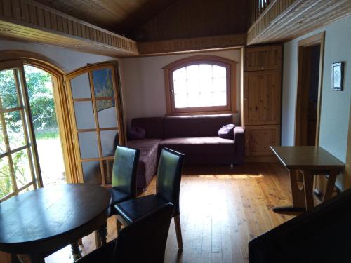 a living room with a couch and a table and chairs at Ferienhaus Kranichhorst - Exklusiv-Nutzung mit großem Garten und Strandnähe in Bodstedt