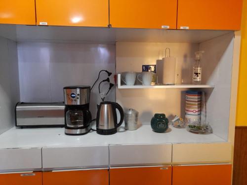ein Küchenregal mit Kaffeemaschine und Mikrowelle in der Unterkunft Bed & Bike Hostel in San Lorenzo