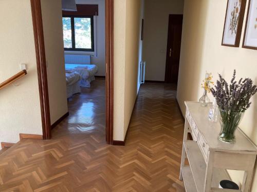 a hallway with a hallway leading to a living room at Los Cedros, gran chalet con piscina y apartamento en Navacerrada in Navacerrada