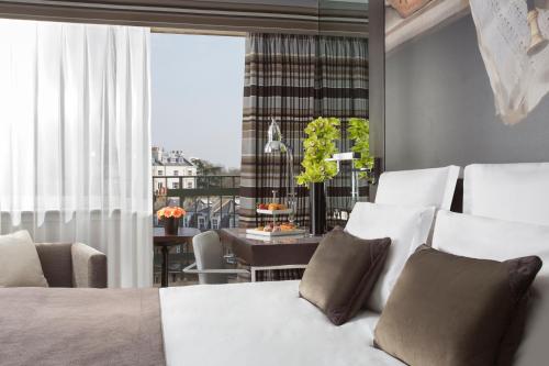 a bedroom with a bed and a dining room at The Lowndes London - A Jumeirah Partner Hotel in London