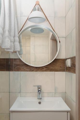 a bathroom with a mirror and a sink at Pod Jasną 28 in Częstochowa
