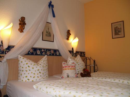 1 dormitorio con 2 camas con almohadas y dosel en Hotel Goldenes Faß, en Würzburg
