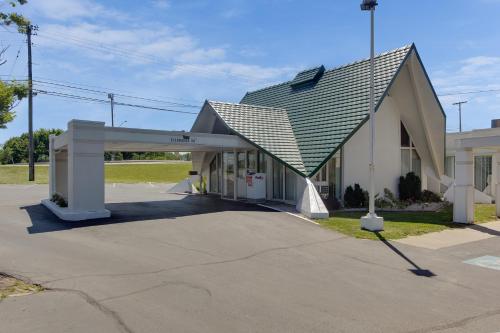 a building with a gambrel roof on top of it at Wingate by Wyndham Geneva at SPIRE Academy in Geneva