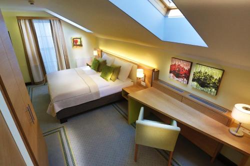 a hotel room with a bed and a desk with a desk at Hotel Leobersdorfer Hof in Leobersdorf