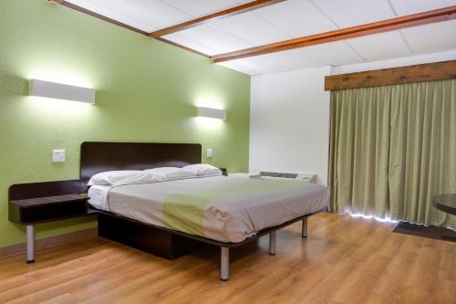 a bedroom with a bed in a room with green walls at Wingate by Wyndham Geneva at SPIRE Academy in Geneva