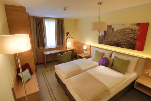 a hotel room with a bed and a desk at Hotel Leobersdorfer Hof in Leobersdorf