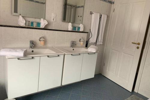 ein Badezimmer mit zwei Waschbecken und einer weißen Tür in der Unterkunft Gemütliche Ferienwohnung im Hunsrück in Dill