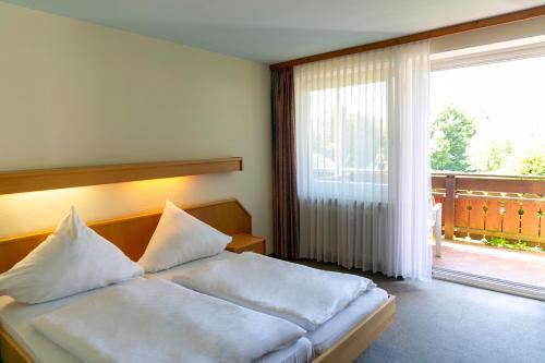 a bedroom with a bed and a large window at Hotel Schwarzwald Freudenstadt in Freudenstadt