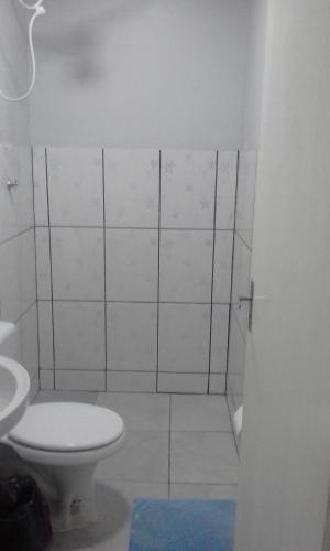 Baño blanco con aseo y lavamanos en Studio Foz do Iguaçu, en Foz do Iguaçu