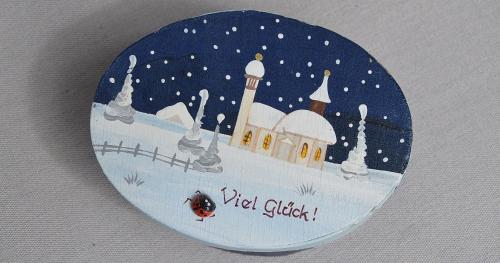 a plate with a picture of a church in the snow at Apartment Krabacher in Seefeld in Tirol