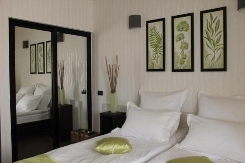 a bedroom with a bed with white pillows and a mirror at Enigma Pension in Târgu Jiu