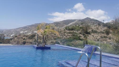 a swimming pool with a view of a mountain at Piso de lujo en la playa de un pueblo de Granada con piscina infiniti, yacuzzi en la piscina, tumbonas privadas y mucho más in Melicena