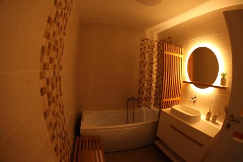 a bathroom with a tub and a sink and a mirror at Studio „Pompei” Brasov in Braşov