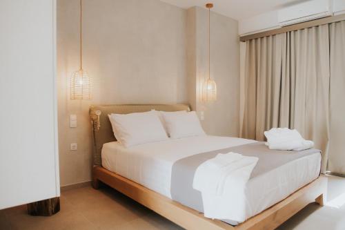a bedroom with a bed with white sheets and pillows at elia boutique hotel in Parga