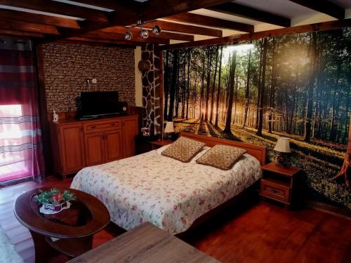 1 dormitorio con 1 cama y un mural de un bosque en Ranch pod lesom Slovensky Raj en Spišský Štiavnik