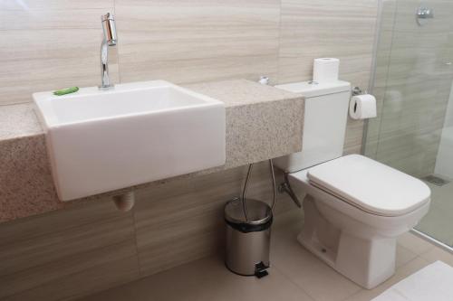 Un baño con lavabo blanco y inodoro. en TS HOTEL, en Porteirinha