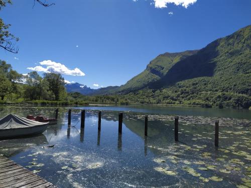 a boat on a lake with mountains in the background at PEONIA 2 posti Wi-Fi AC free park Jacuzzi in Porlezza