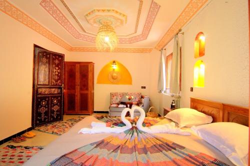 a bedroom with a bed with a swan on it at Jnane Karma in Imlil