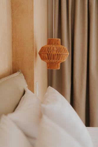 a wicker lamp is hanging over a bed at elia boutique hotel in Parga